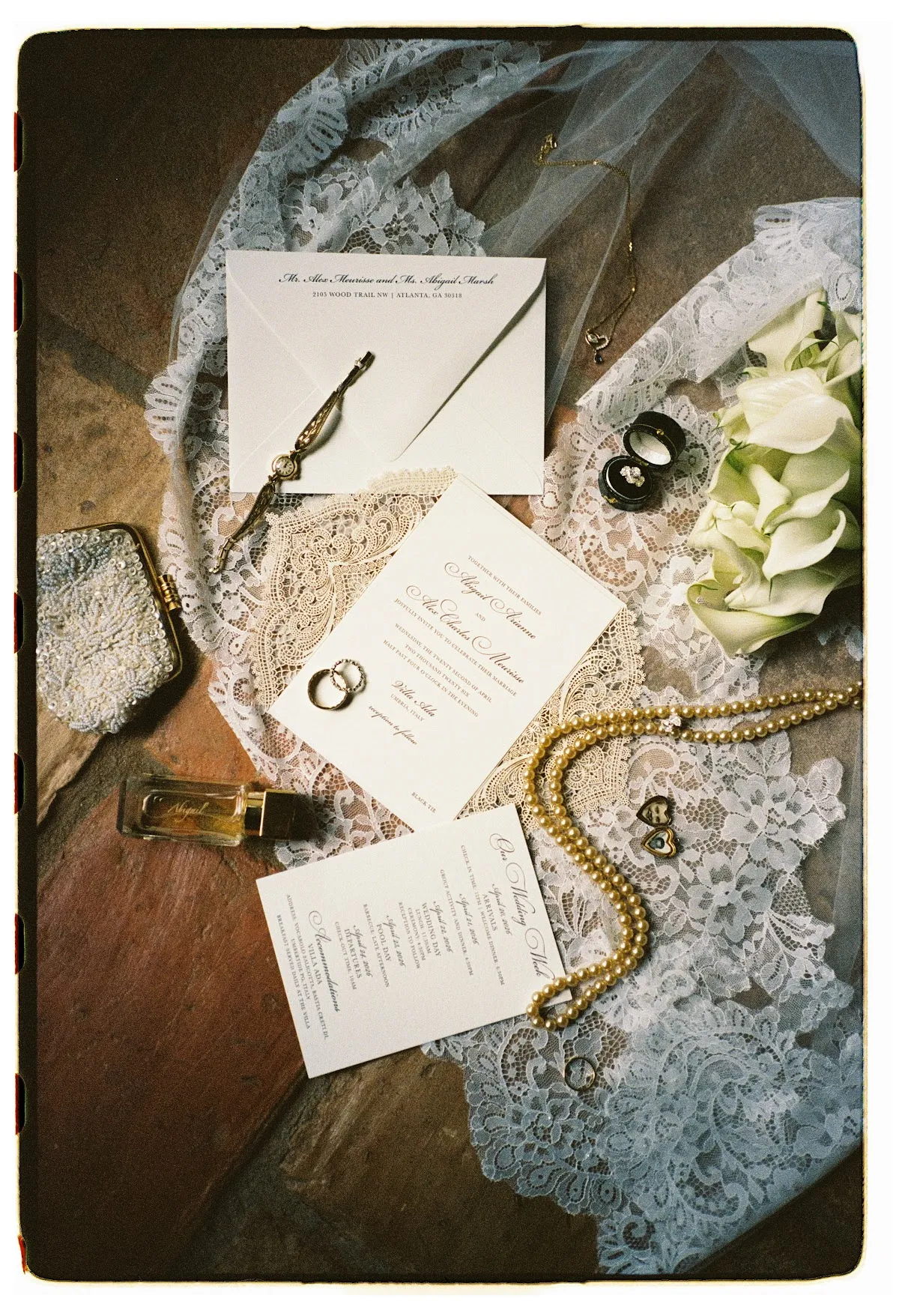 Bridal details including lace invitations and heirloom jewelry